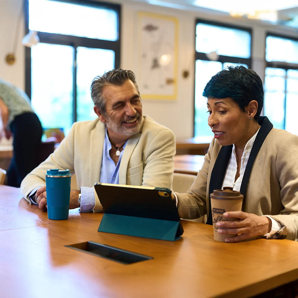 Two professionals reviewing data on a tablet during analysis meeting